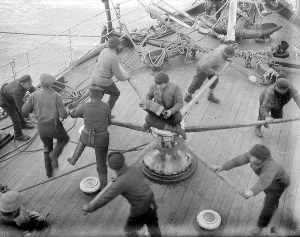 A crew on a ship spinning a wheel together